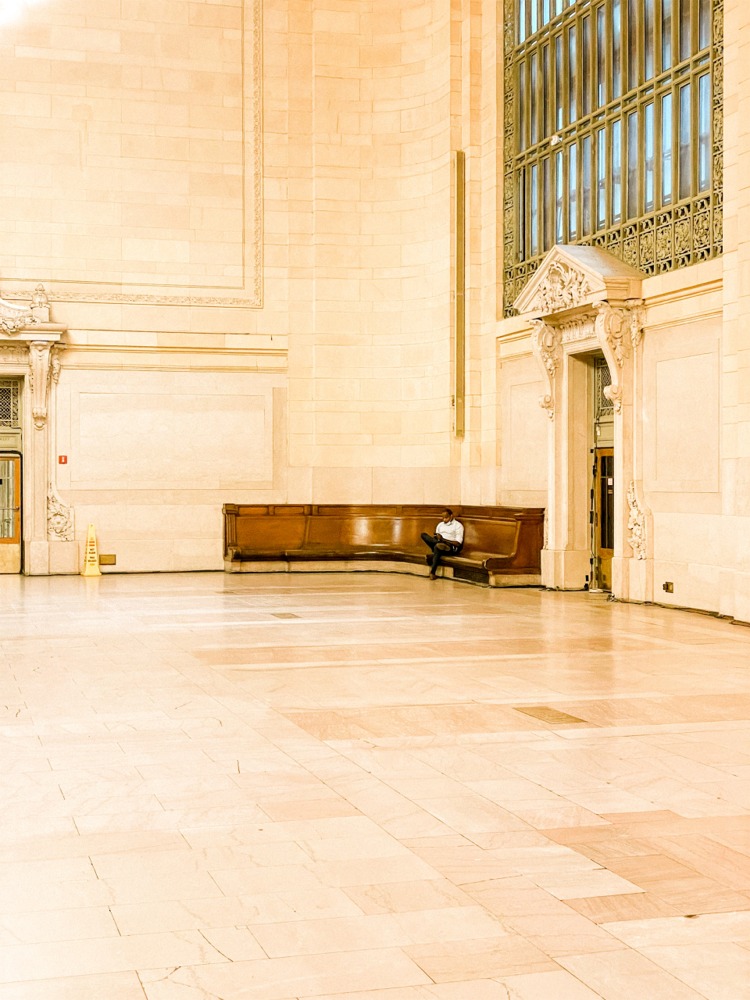 A man sitting inside Grand Central Terminal. Away from the tourists, this man finds a space to rest and relax, New York City ny nyc