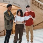 People standing in front of a staircase to the dining concourse reading a subway map in Grand Central Terminal, New York City ny nyc