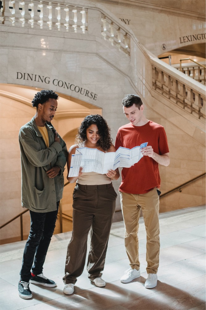 People standing in front of a staircase to the dining concourse reading a subway map in Grand Central Terminal, New York City ny nyc