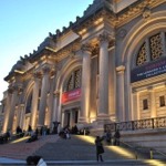 This photograph shows the Fifth Avenue facade of The Metropolitan Museum of Art in New York City at twilight.