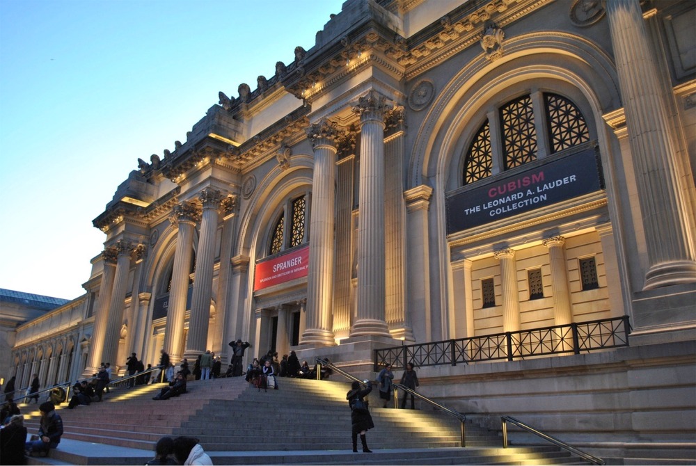 This photograph shows the Fifth Avenue facade of The Metropolitan Museum of Art in New York City at twilight.