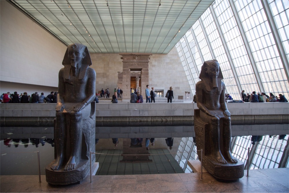 This photograph shows two statues (frontal view) of Amenhotep III at the Temple of Dendur in the Metropolitan Museum of Art in New York.