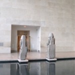 This photograph shows two statues (rear view) of Amenhotep III at the Temple of Dendur in the Metropolitan Museum of Art in New York.