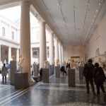 This photograph shows a large gallery enclosed by a colonnade filled with stone sculptures from ancient Rome and Greece.