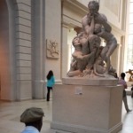 This photograph shows an artist drawing the statue of Ugolino and His Sons in the European Sculpture Court at the Metropolitan Museum of Art in New York City.
