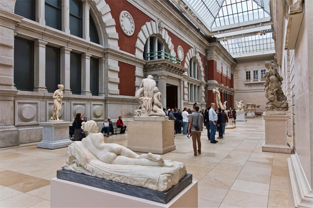 This photograph shows people in the Carroll and Milton Petrie European Sculpture Court at the Metropolitan Museum of Art in New York City.