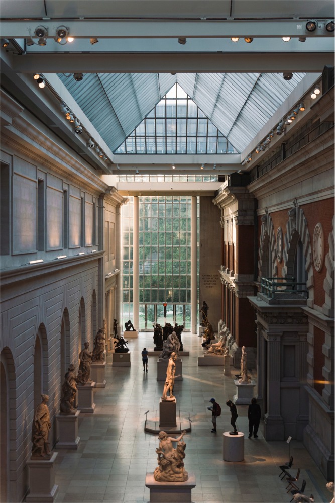This photograph shows people in the Carroll and Milton Petrie European Sculpture Court at the Metropolitan Museum of Art in New York City.